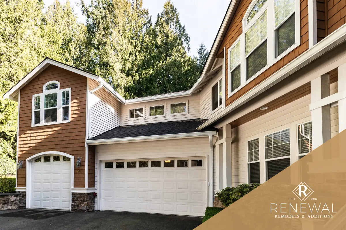 Home exterior with two garage doors, upper-story windows, and a paved driveway.