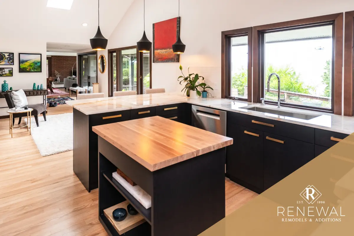 Kitchen with dark cabinetry, a central island, pendant lighting, and an open connection to the adjoining living area.